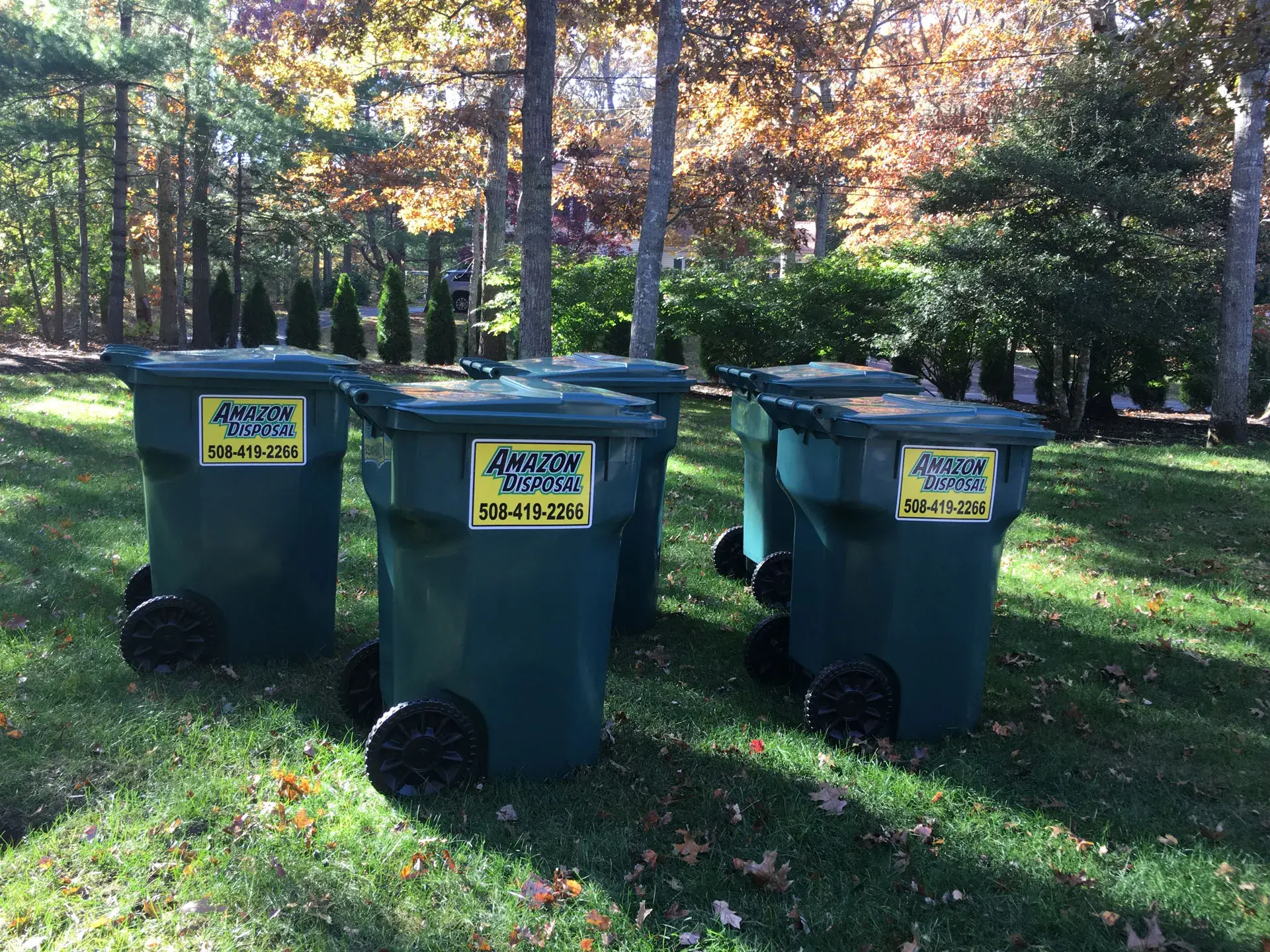 Amazon Disposal branded 95-gallon animal-proof totes lined up on a lawn in Cape Cod